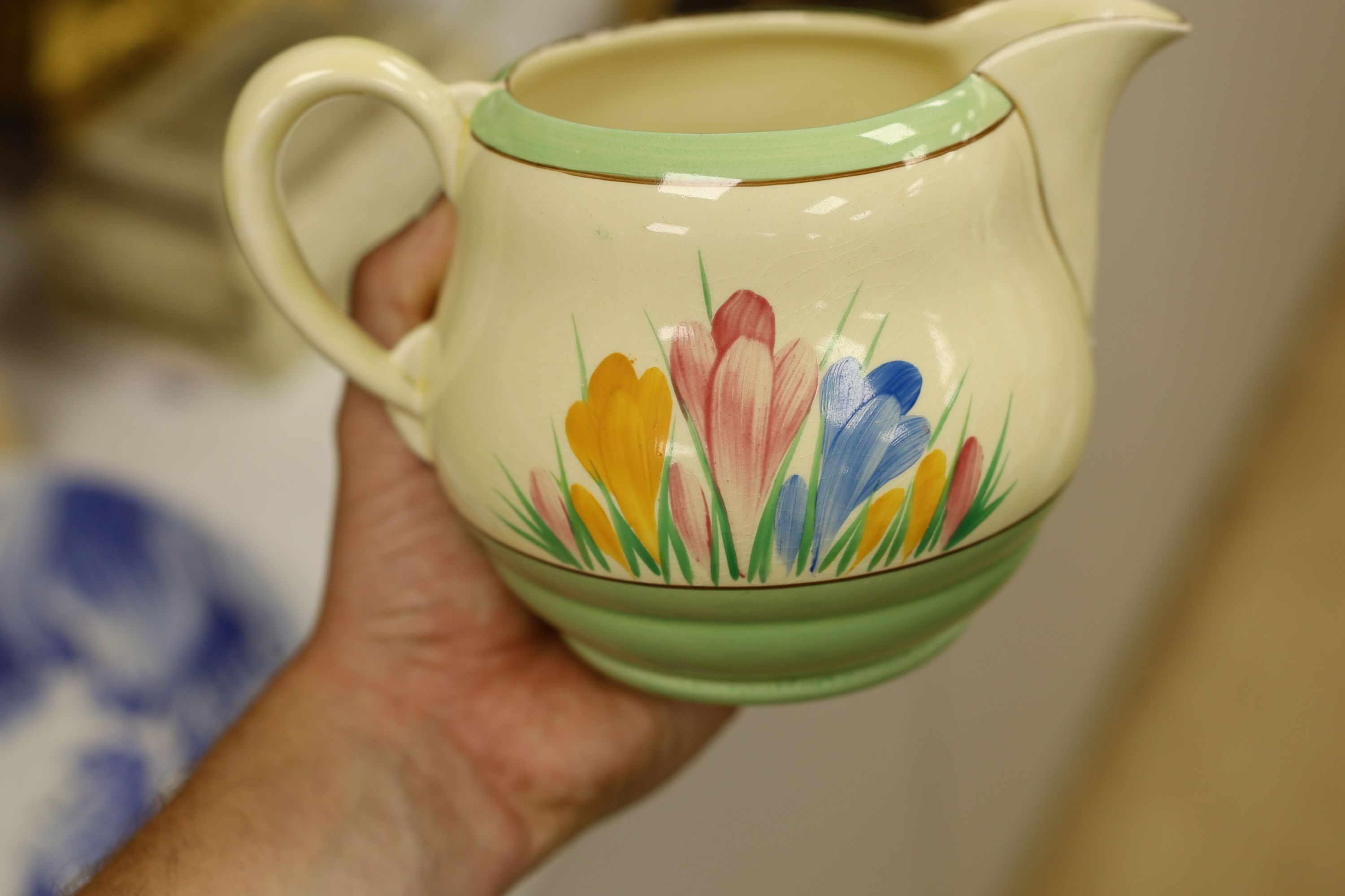 A Clarice Cliff crocus design milk jug and a Bizarre patterned side plate, jug 11.5 cms high